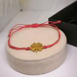 Punase niidi käevõru kuldse neljalehelise ristikheina motiiviga