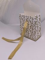 Valge kingituse karp kuldsete ornamentide ja lindiga